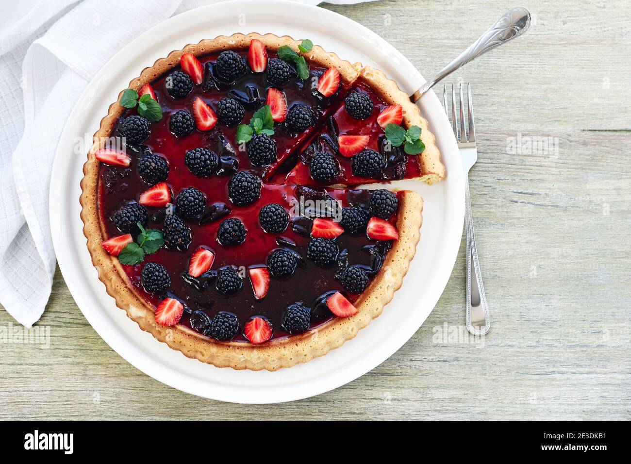 Crostata di frutti di bosco con more e fragole su un tavolo di legno, vista dall'alto. Foto Stock