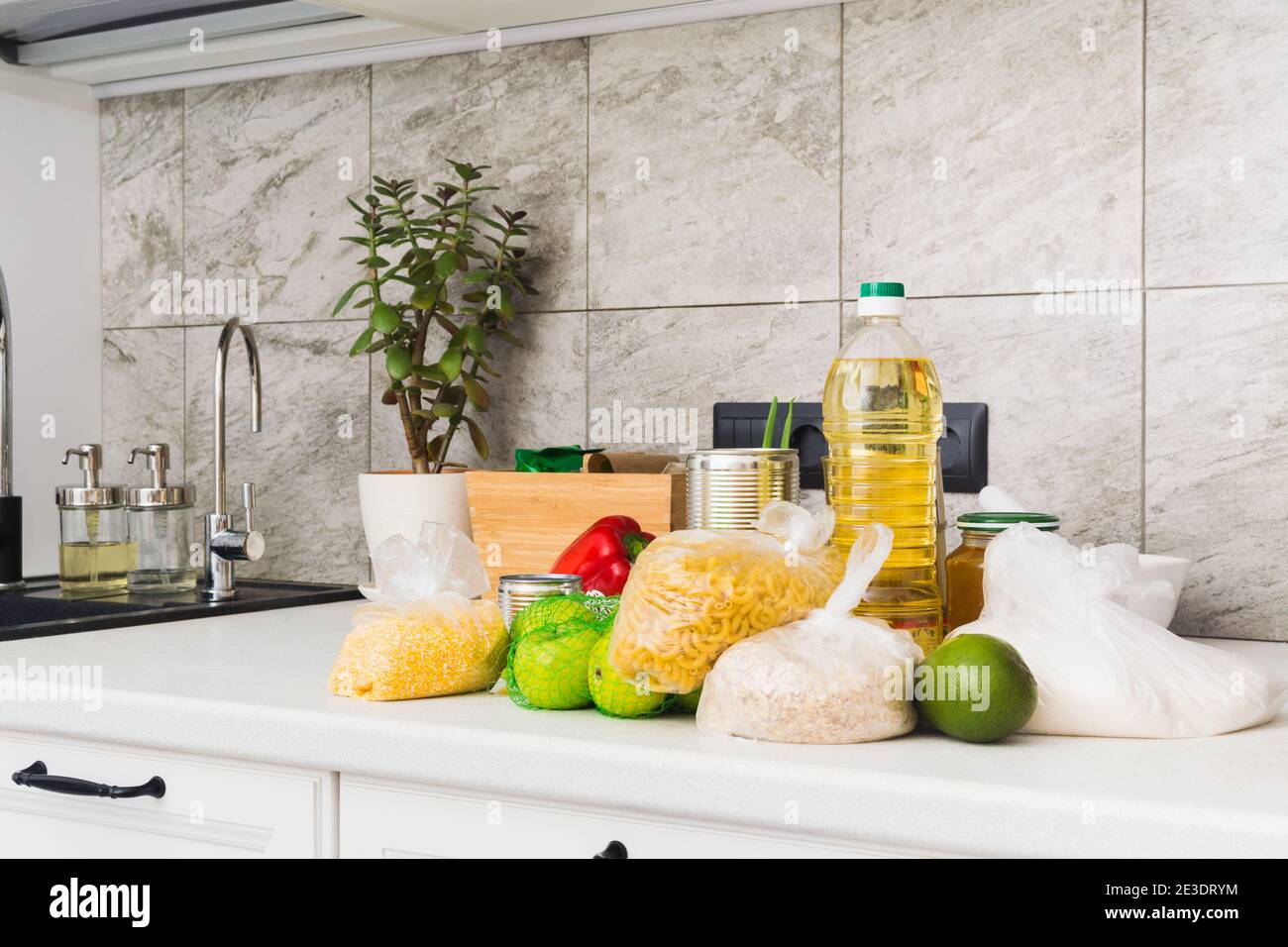 Parte di cucina con diversi alimenti sul tavolo. Concetto di carità. Cestino di cibo Foto Stock
