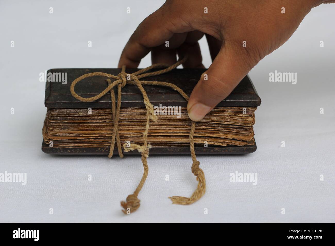 I vecchi manoscritti delle foglie di Palm si legano insieme in un libro e. mano umana che lo tiene Foto Stock