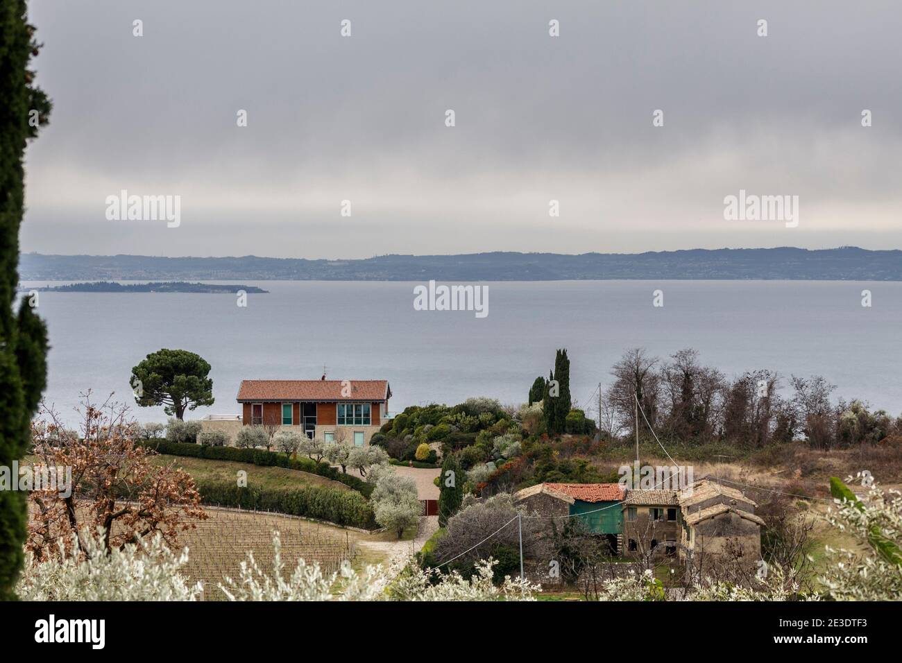 Bardolino, Italia - 01 05 2021: Casa rustica e moderna con sullo sfondo la piccola penisola di Sirmione. Foto Stock