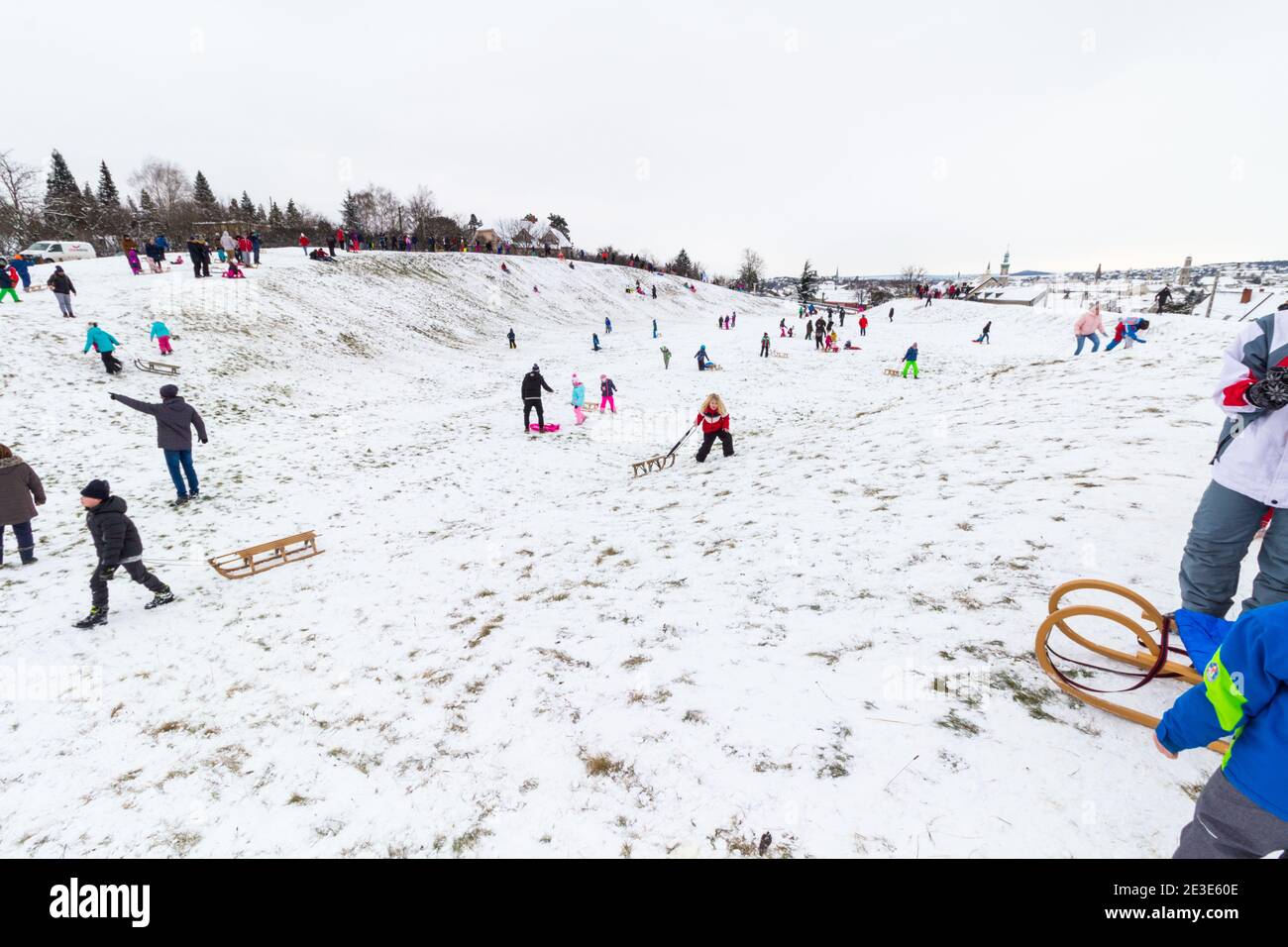 Bambini e adulti che slittano sul sito dell'antico Anfiteatro in inverno a Becsi-domb, Sopron, Ungheria Foto Stock