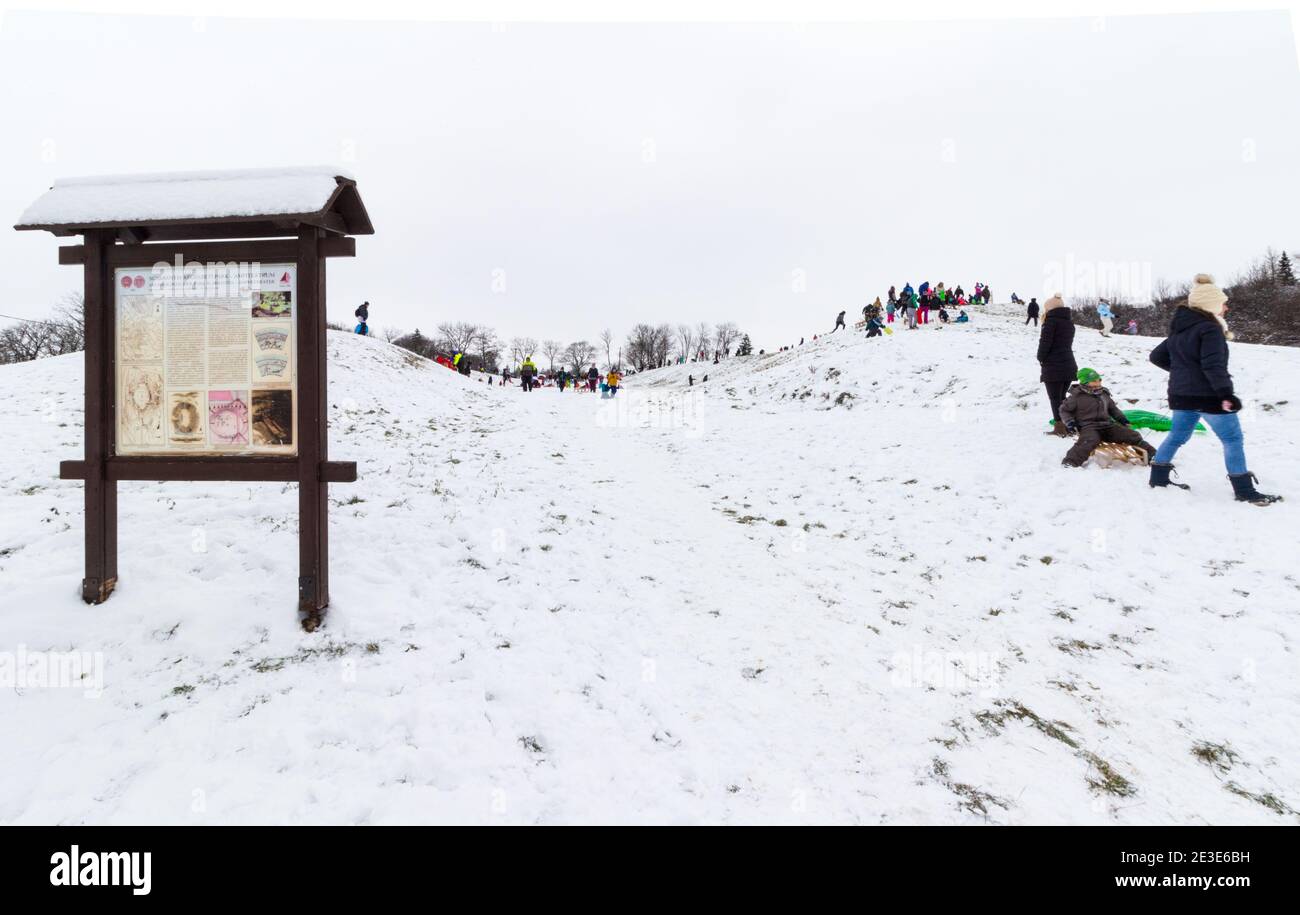 Bambini e adulti che slittano sul sito dell'antico Anfiteatro in inverno a Becsi-domb, Sopron, Ungheria Foto Stock