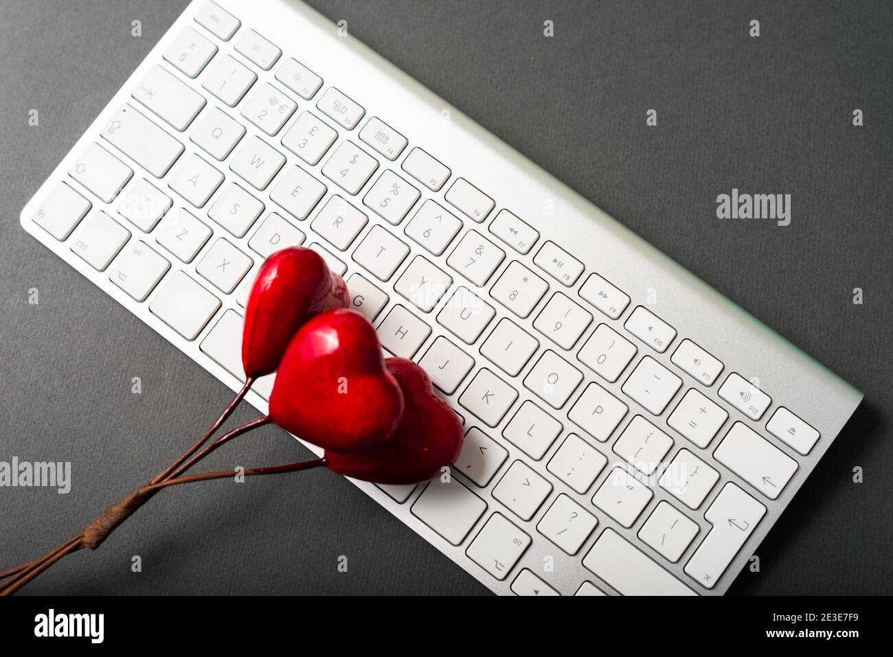 Foto della tastiera bianca e della forma del cuore rosso. Foto Stock