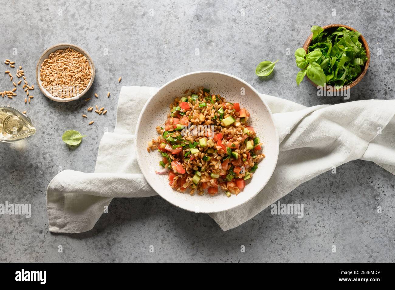 Gustosa insalata fatta in casa di farro di cereali interi con verdure fresche su tavola grigia. Vista dall'alto. Foto Stock