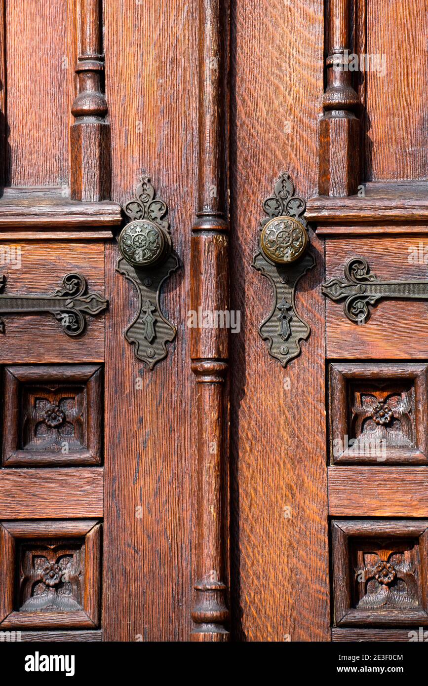 Vecchie porte esterne in legno con pannelli decorativi, pomelli in ottone e dettagli. Foto Stock