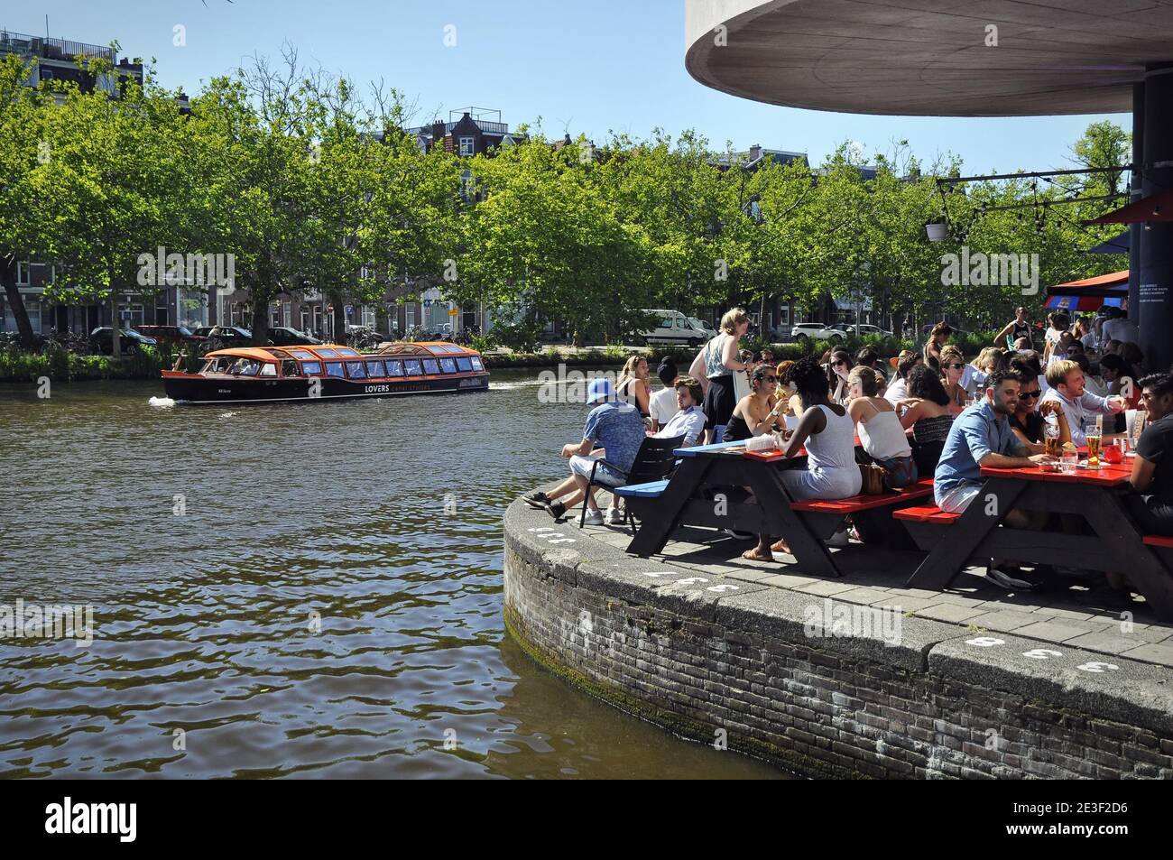 Il pub affollato sul lato del Singelgracht. Il cliente è seduto su panchine di legno sul lato del canale Foto Stock