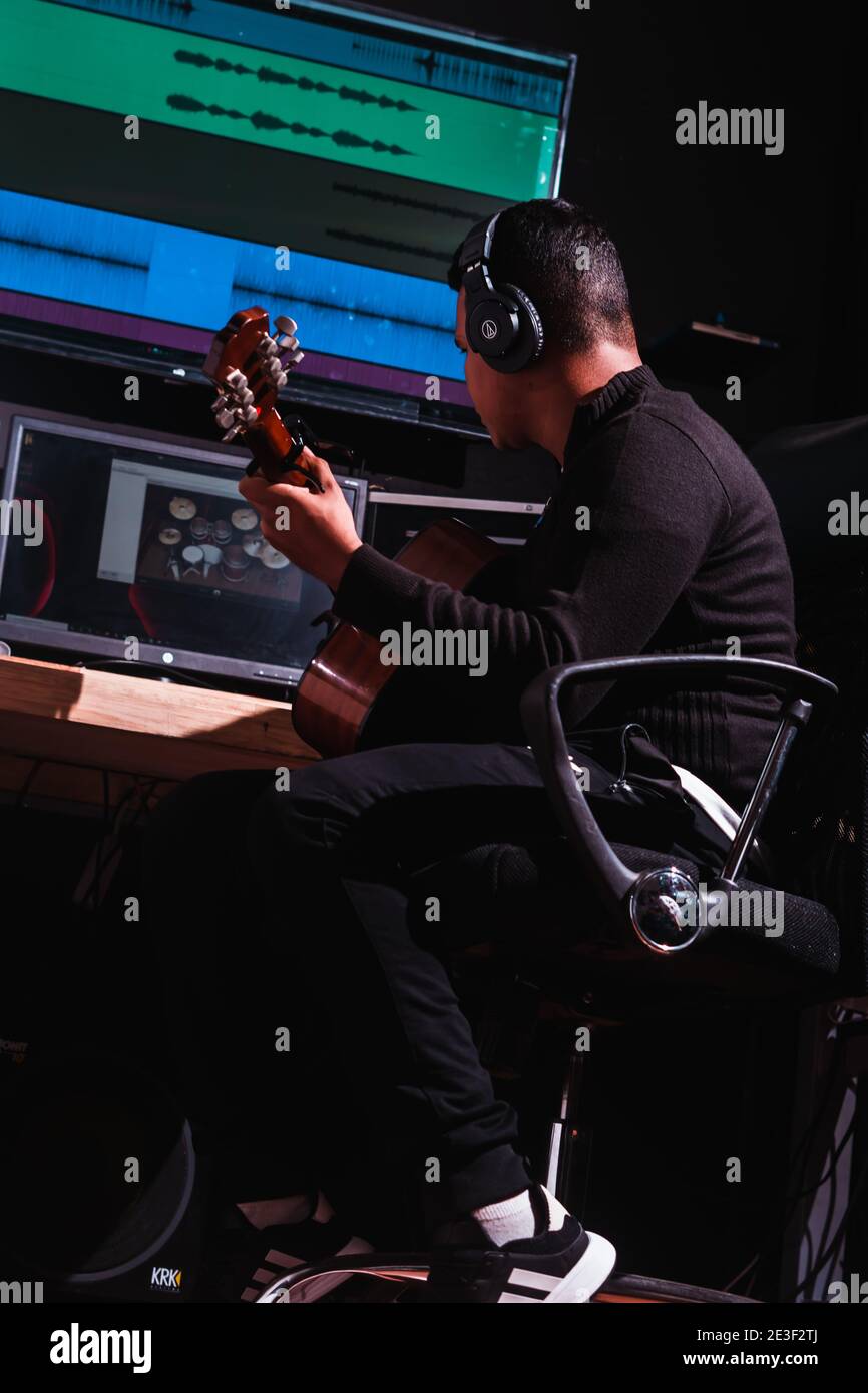 Ripresa verticale di una chitarra maschile in studio Foto Stock