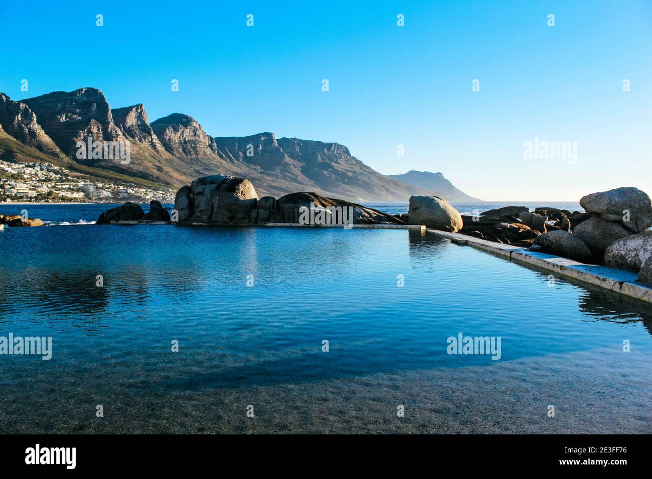 Paesaggio scenico e sereno delle piscine naturali blu scuro di marea di Maiden's Cove vicino a Camps Bay in Sud Africa Foto Stock