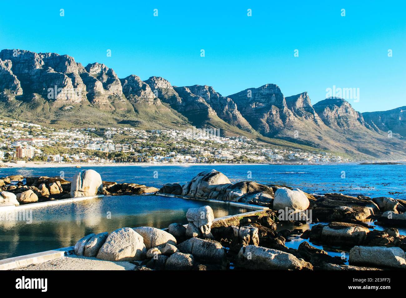 Paesaggio scenico e sereno delle piscine naturali blu scuro di marea di Maiden's Cove vicino a Camps Bay in Sud Africa Foto Stock