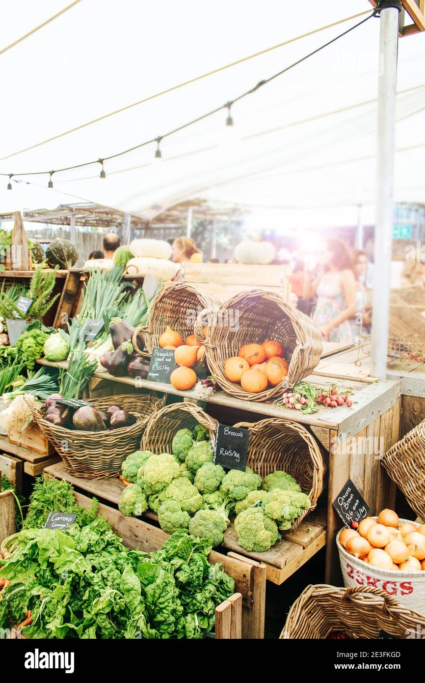 Verdure e frutta su scaffale di legno che vengono venduti al mercato agricolo di Oranjezicht City a Città del Capo, Sud Africa Foto Stock