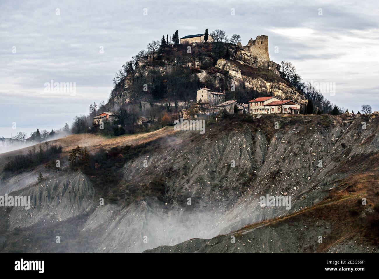 Vista panoramica dello spettro del Castello Matilde Canossa sulla cima di Badlands durante una giornata di nebbia, Reggio Emilia, Italia Foto Stock