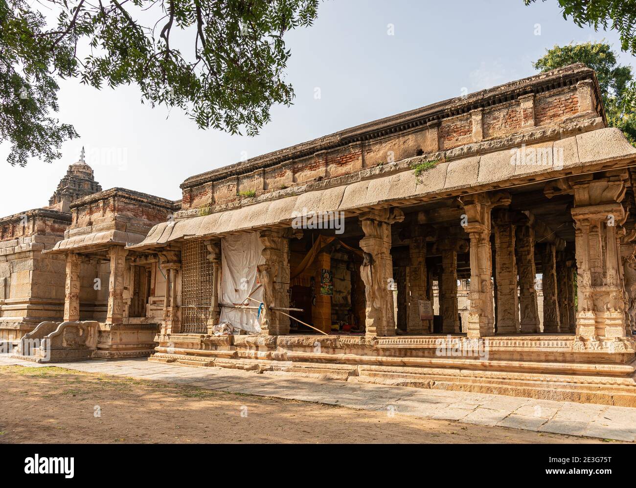 Hampi, Karnataka, India - 5 novembre 2013: Tempio Malyavanta Raghunatha. I rovinosi edifici in pietra marrone sono la sala Mandapam e il santuario contro la luce bl Foto Stock
