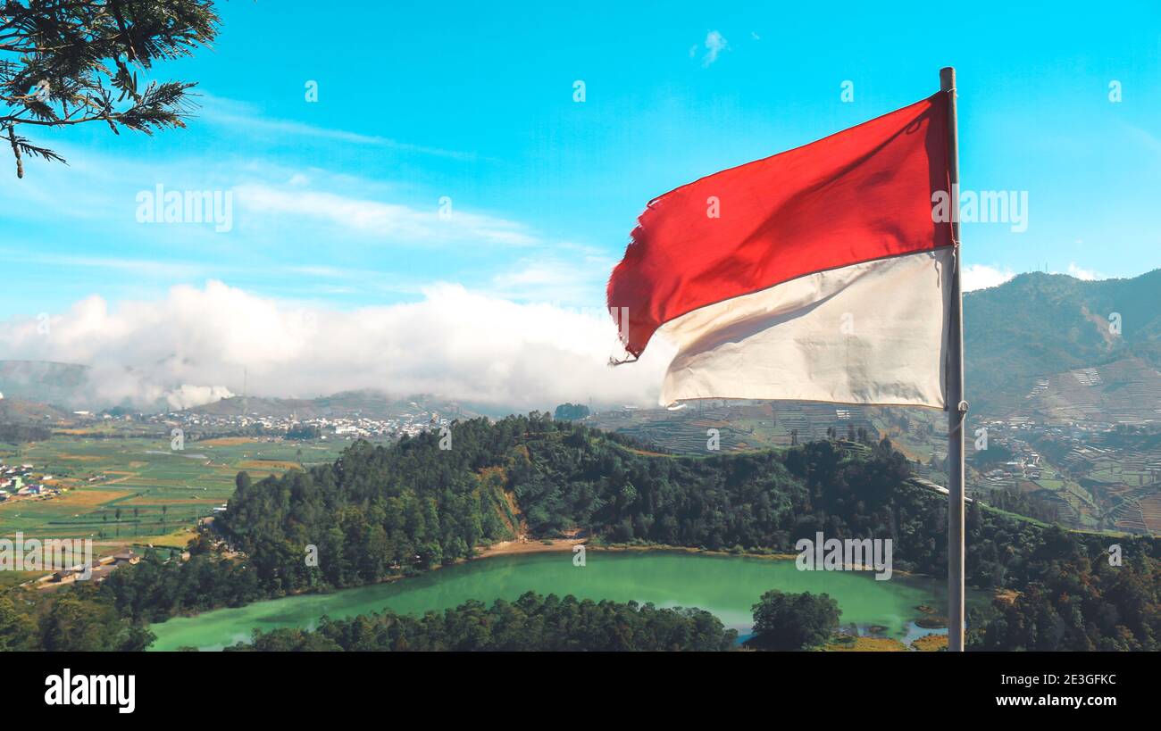 Bandiera Indonesiana sul lago e montagna Telaga Warna a Dieng Indonesia. Foto Stock Bandiera Indonesiana sul lago e montagna Telaga Warna a Dieng Indonesia. Foto Stock