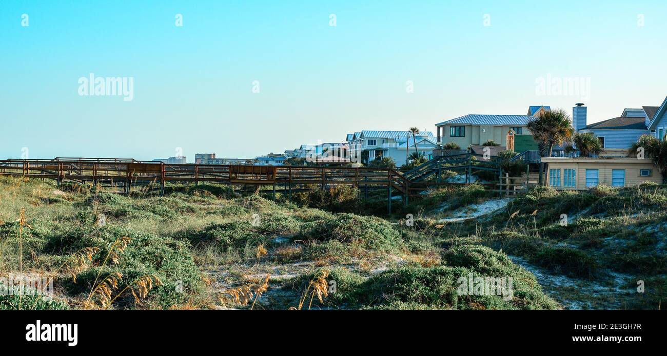 Case sulla spiaggia accoccolate tra le dune con passerelle in legno per la spiaggia e l'Oceano Atlantico a Fernandina Beach, sull'Isola di Amelia, FL Foto Stock