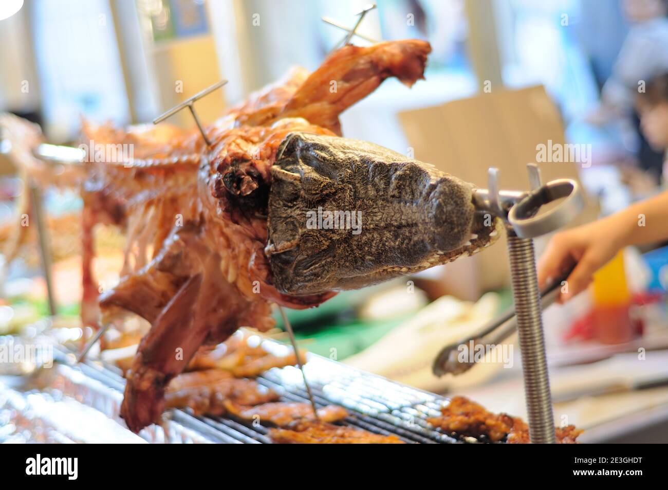 Carne di coccodrillo alla griglia venduta in un mercato di strada Foto Stock