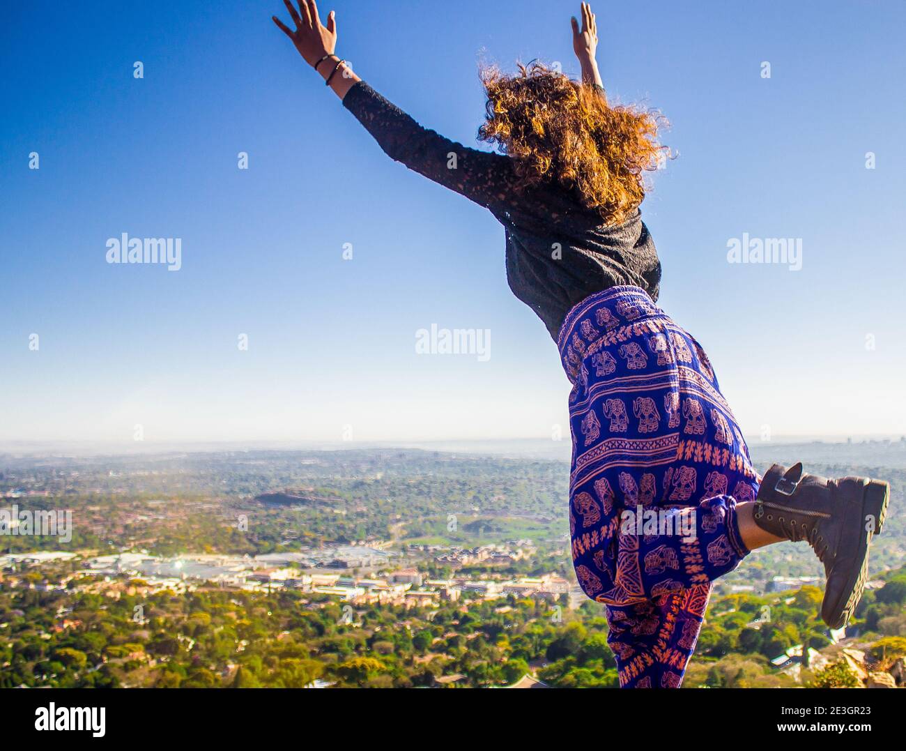 Donna che salta in collina Foto Stock
