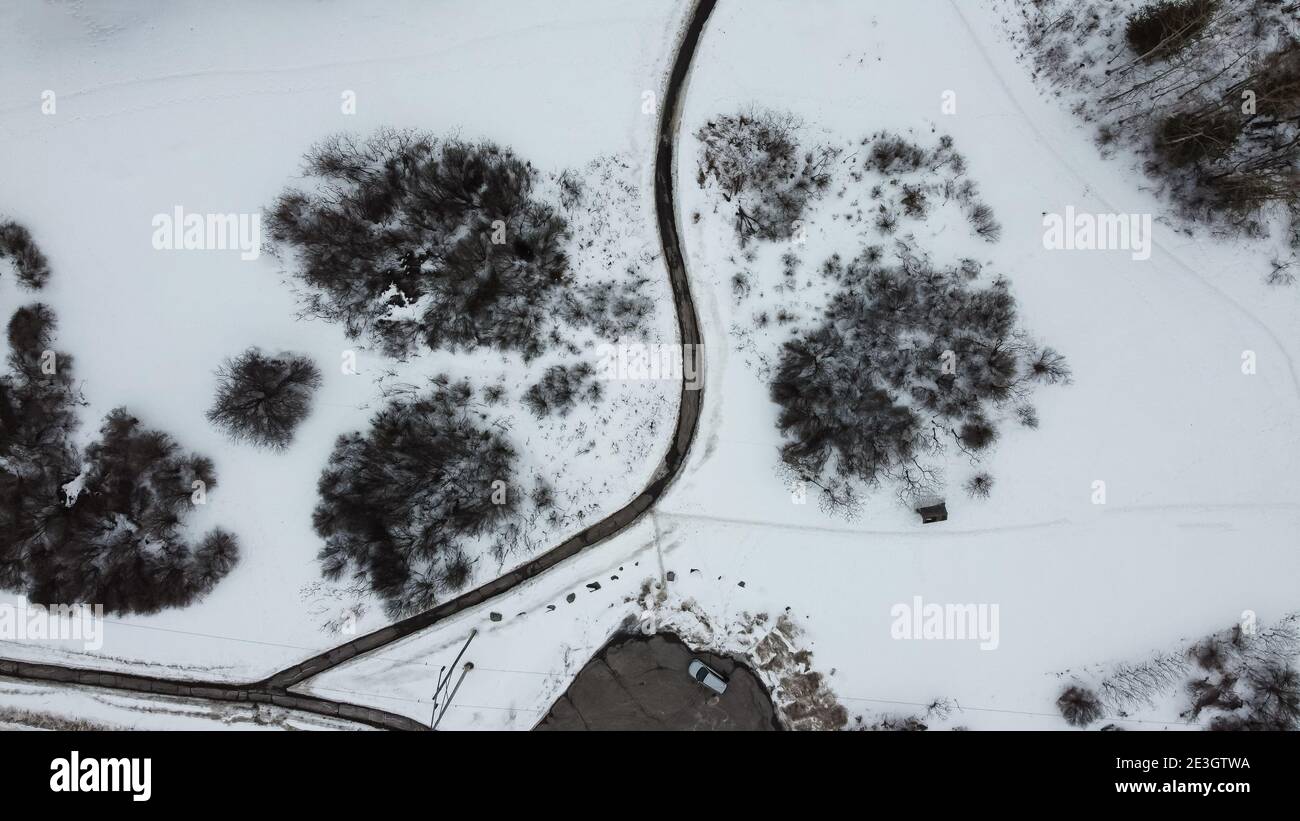 Vista aerea dall'alto di un sentiero pedonale in inverno , circondato da neve. Il quartiere di Kanata può essere visto sullo sfondo. Ottawa, Ontario, Canada Foto Stock