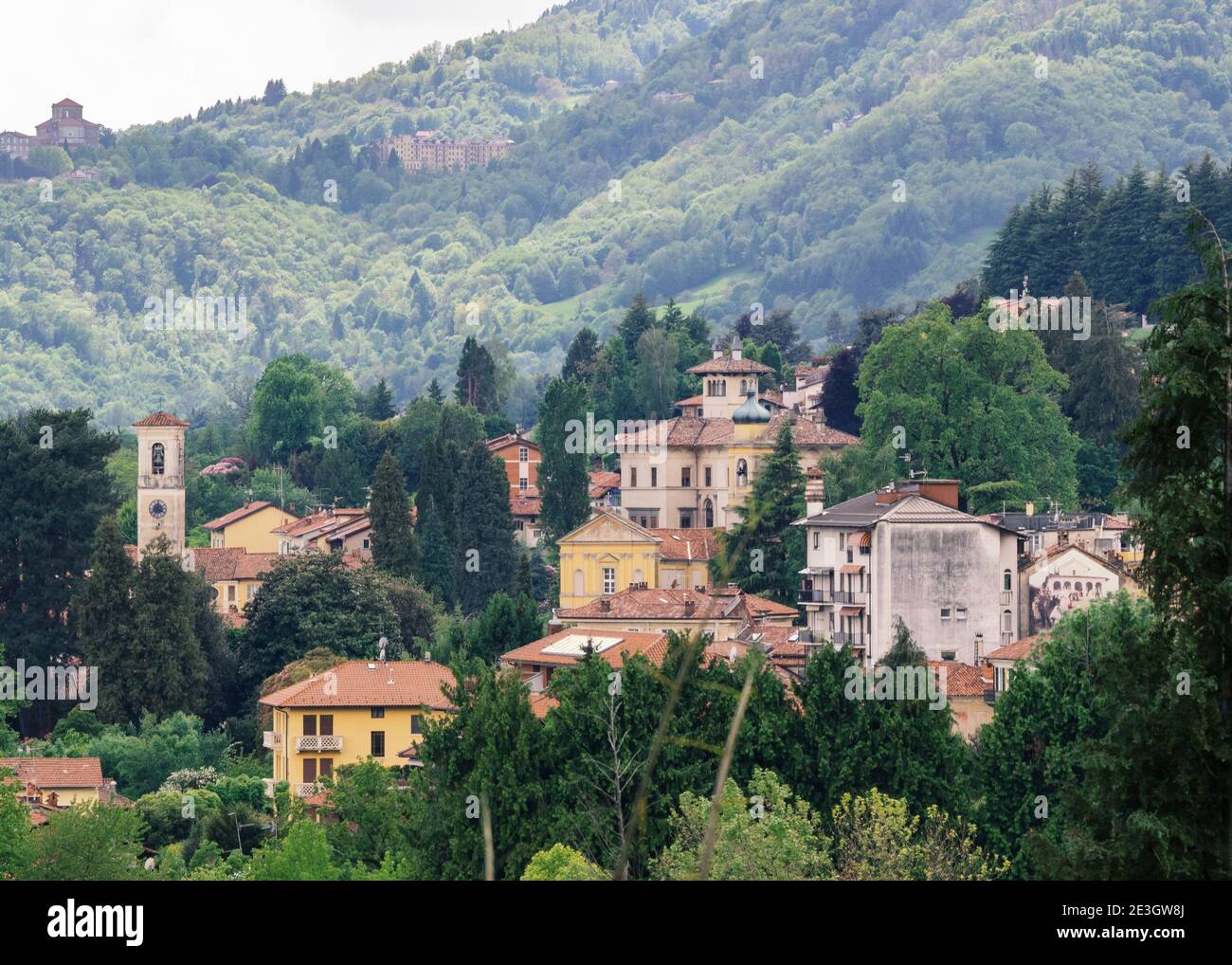 Veduta aerea di un paese con poche case sulle colline piemontesi immerso nel verde dei boschi. Biella, Italia. Foto Stock