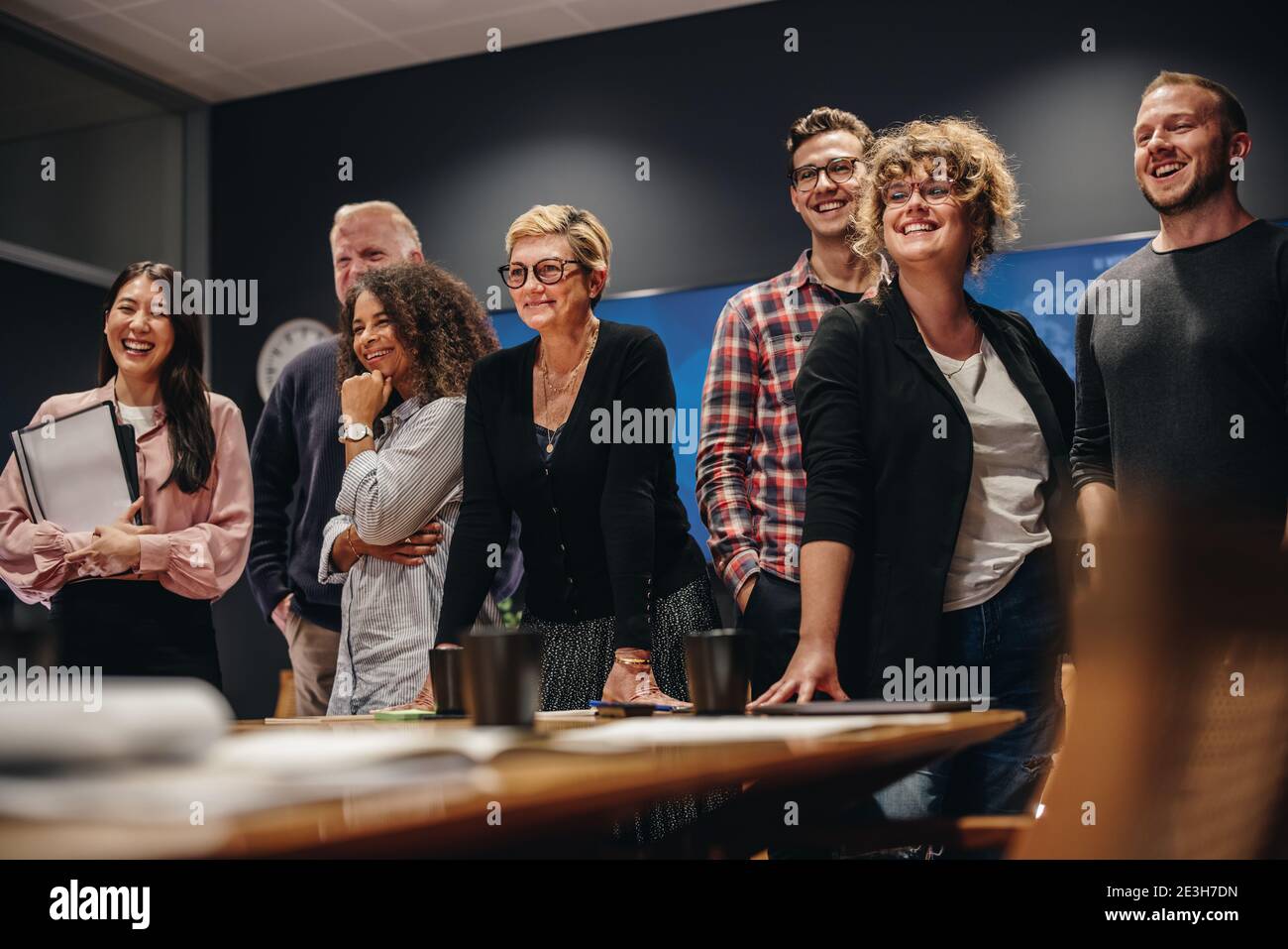 Squadra di professionisti maschili e femminili in piedi insieme. gruppo di lavoro nella sala meeting in piedi per un ritratto. Foto Stock