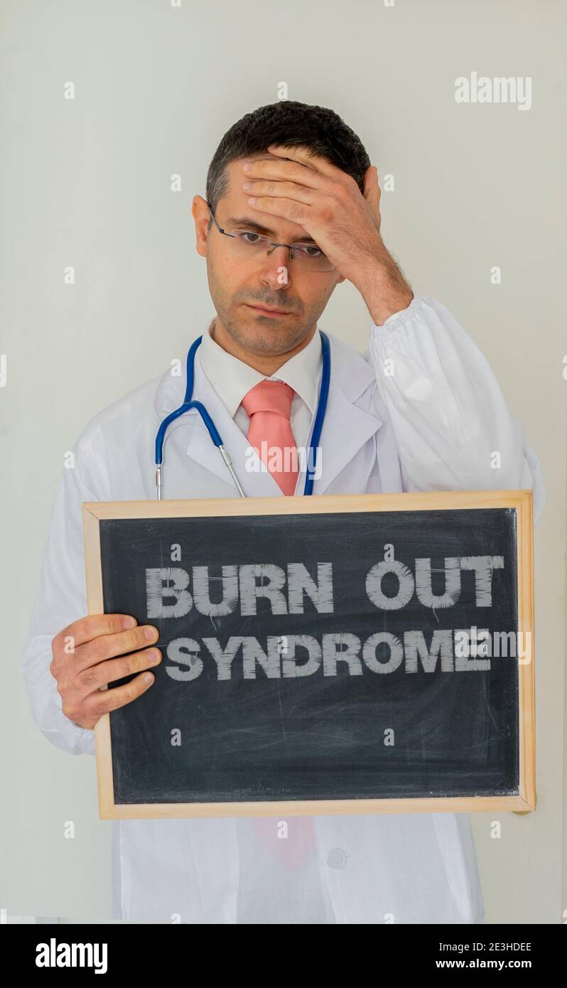 Sindrome da ustione nel concetto personale sanitario. Il medico depresso mostra un'ardesia con sindrome di burnout scritta su di essa. Foto Stock