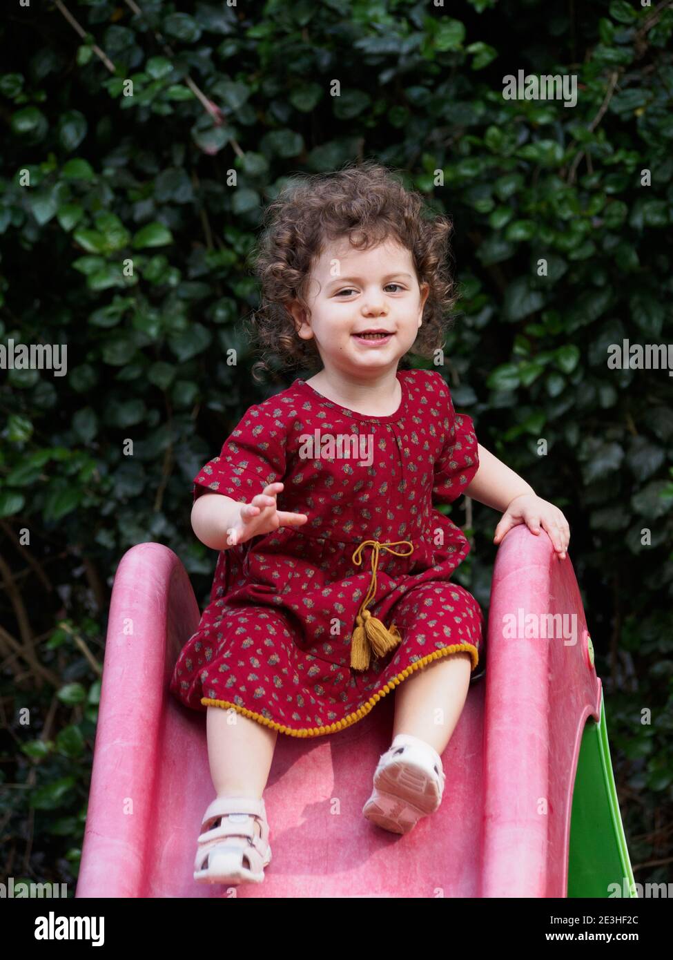 La ragazza del toddler gioca all'aperto nel suo giardino Foto Stock