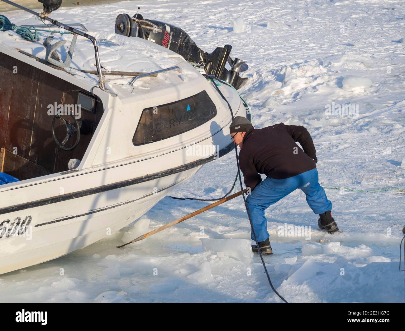 La barca da pesca è trainata dal ghiaccio marino all'acqua aperta. Inverno nel porto ghiacciato della città Ilulissat sulla riva della baia di Disko. America, Nord America Foto Stock