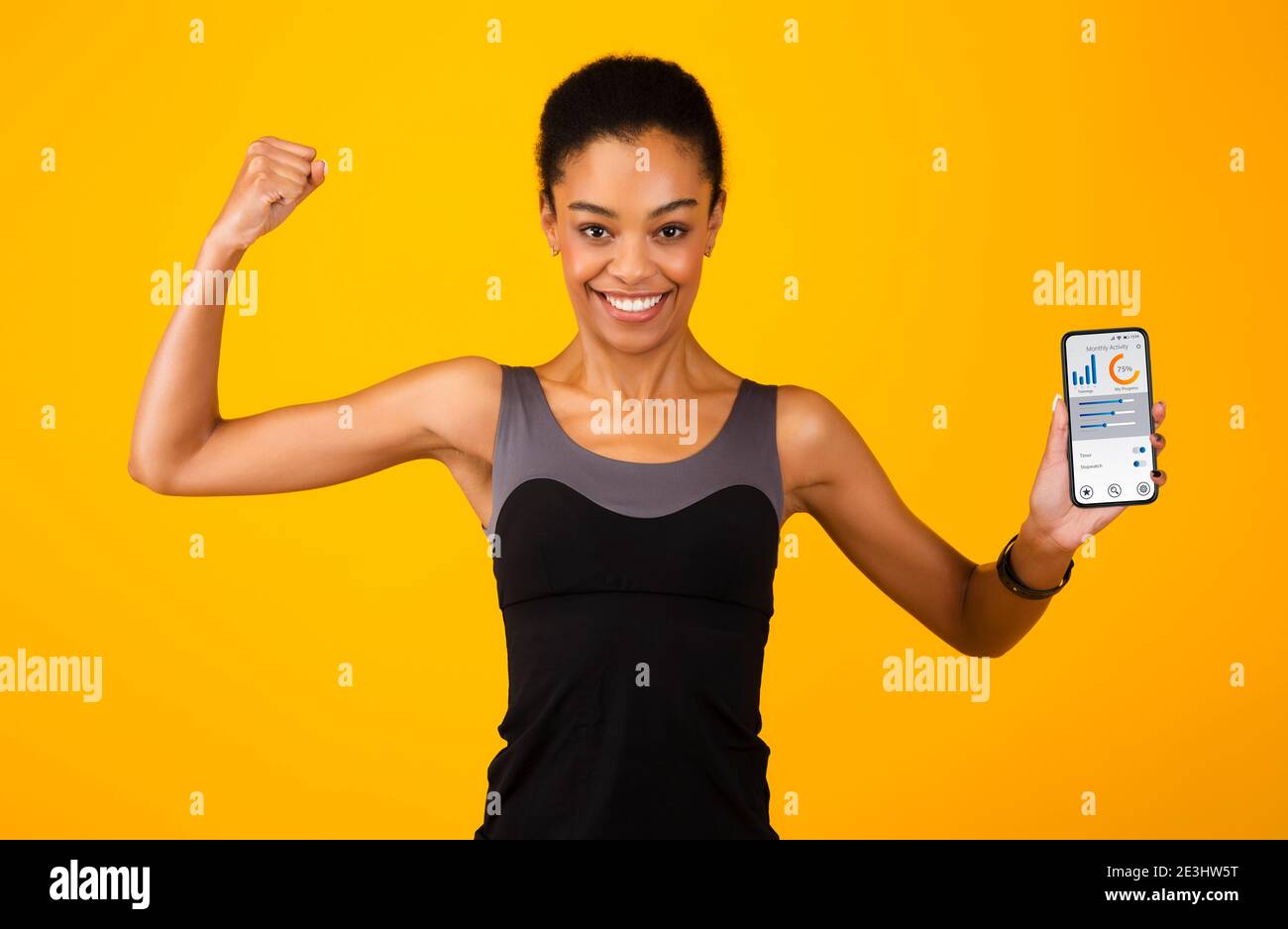 African Lady che mostra il telefono con l'applicazione Activity Tracker, sfondo giallo Foto Stock