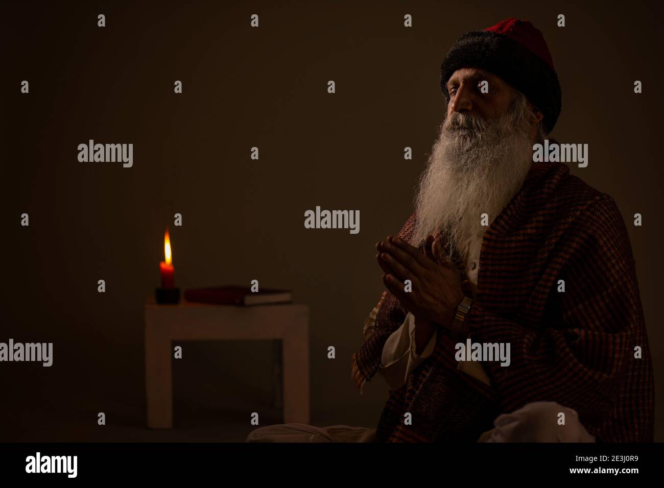 UN VECCHIO SOPPORTATO CHE PREGA A DIO CON LE MANI RIPIEGATE Foto Stock