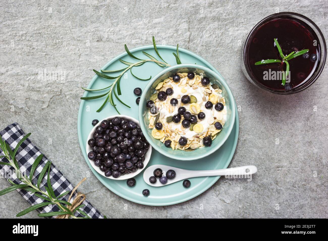 Yogurt greco, muesli con mirtilli e succo di frutta fresco su un tavolo di pietra, vista dall'alto con spazio per il testo. Cibo sano, snack o colazione. Foto Stock