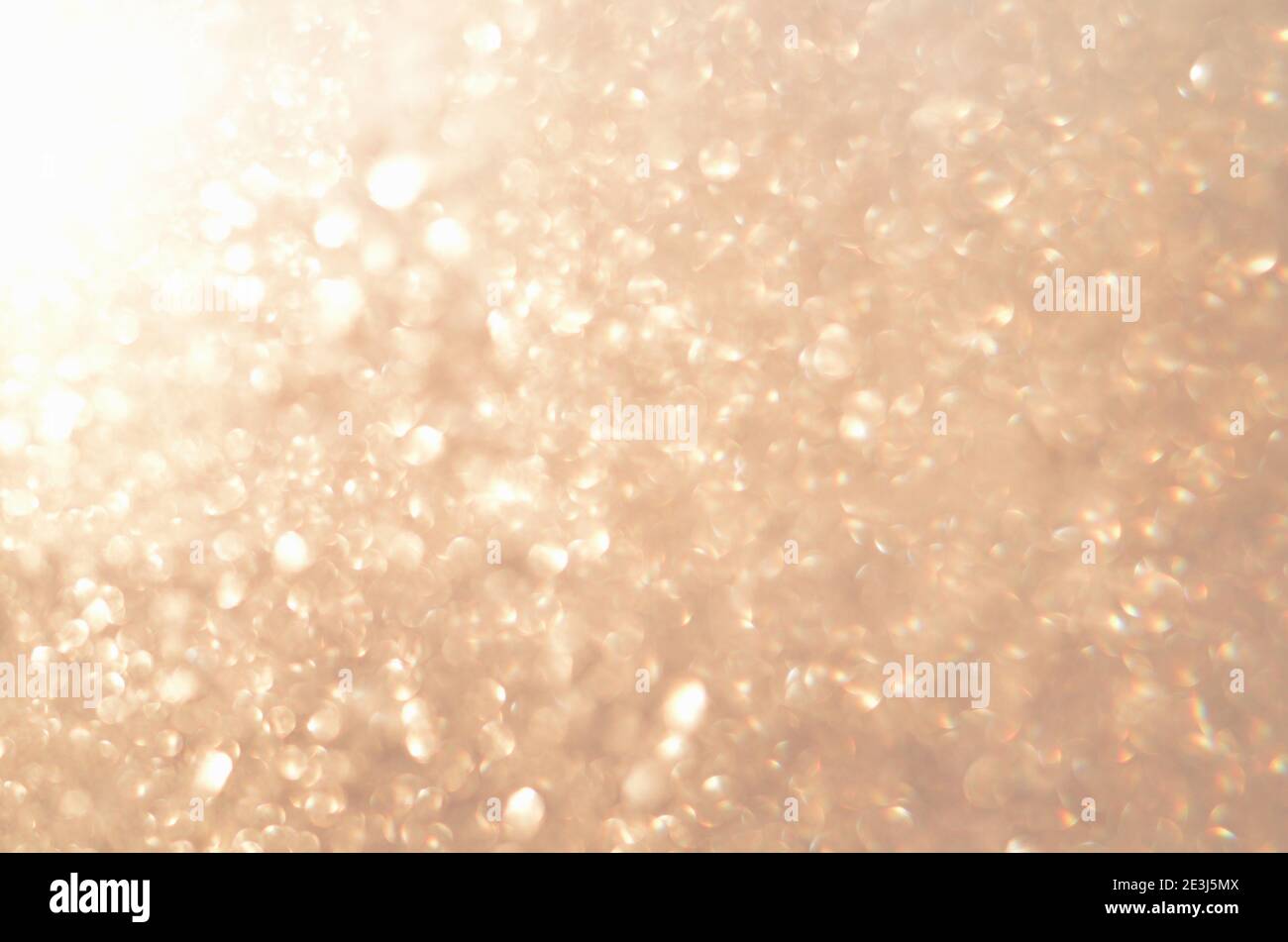 Sfondo glitterato astratto con luce dorata soffusa e sfocata. Immagine sfocata. Foto Stock