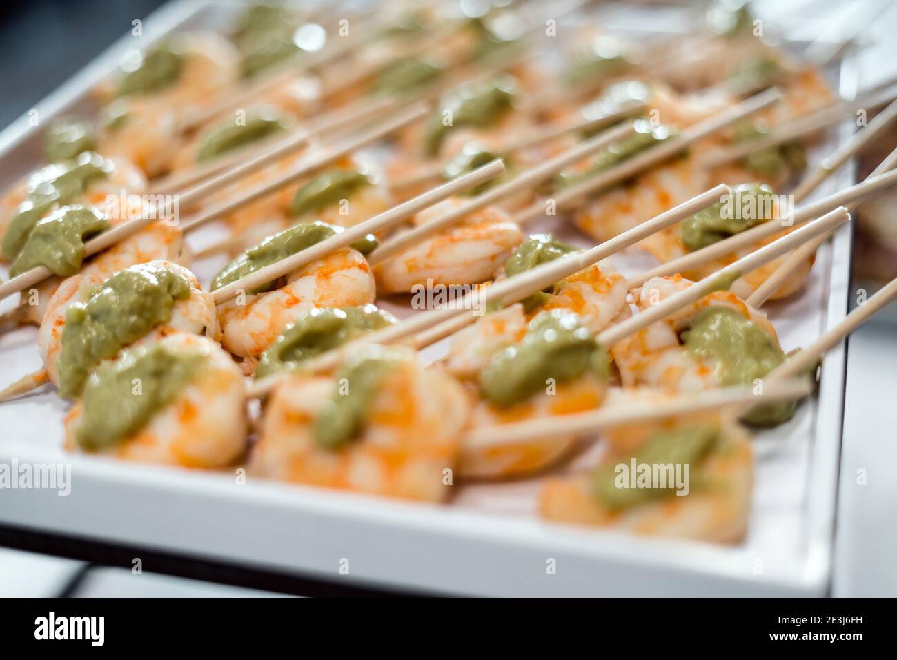 Gamberetti con pasta di avocado su bastoncini serviti come antipasto Foto Stock