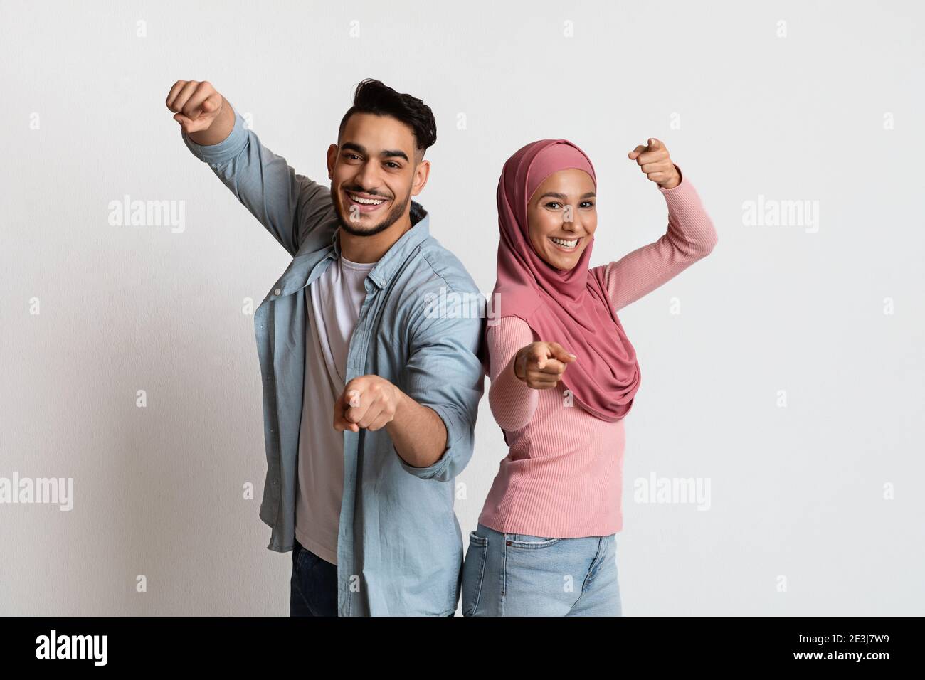 Gotcha. Allegra coppia musulmana che punta le dita verso Camera, indicando qualcuno Foto Stock