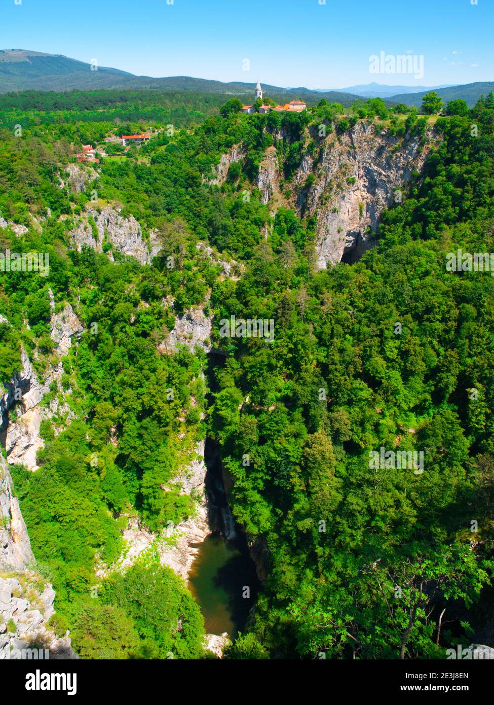 Vista della gola profonda del fiume Reka e villaggio con chiesa rurale, grotte di Skocjan, Slovenia Foto Stock