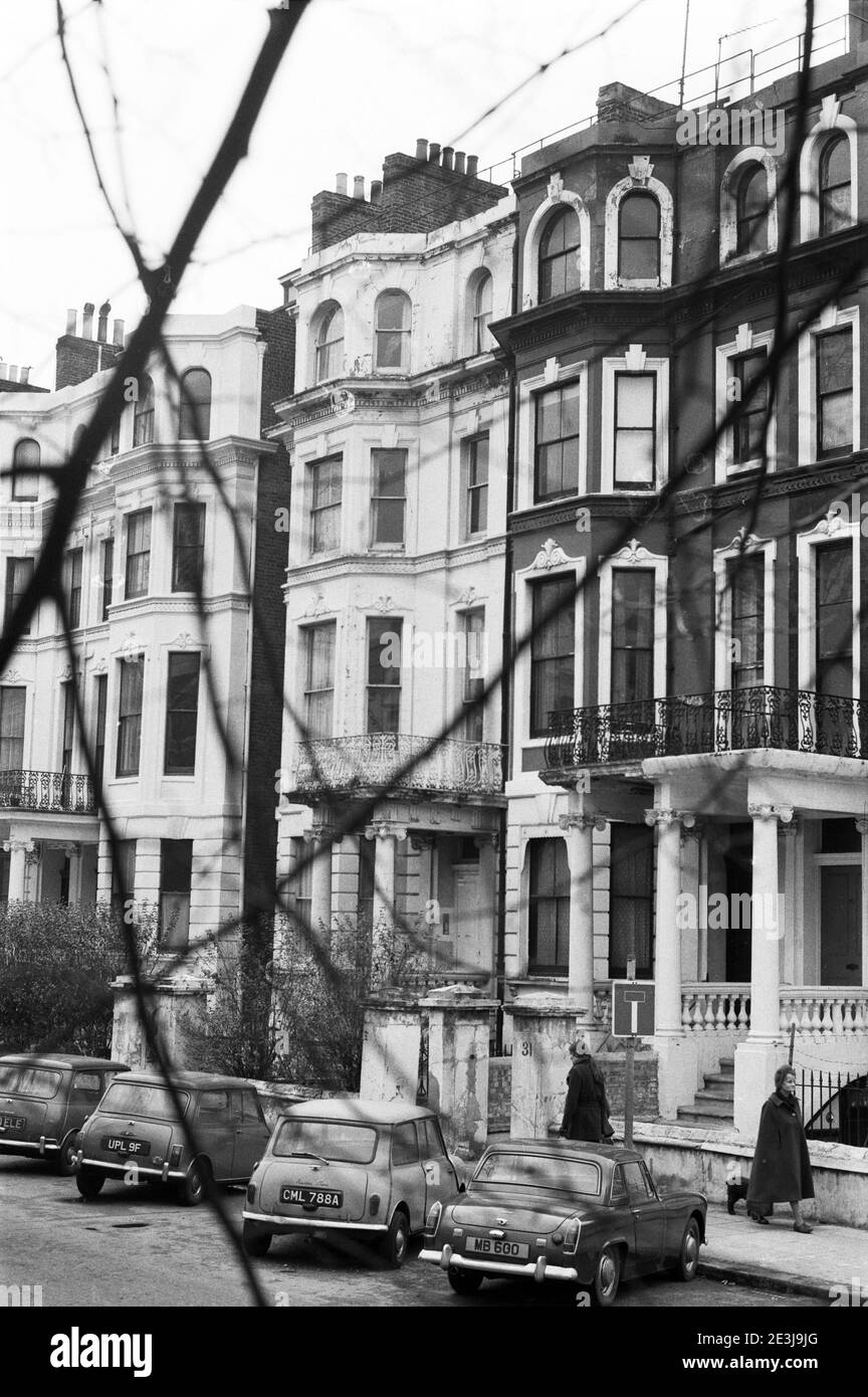 UK, West London, Notting Hill, 1973. Rundown e faticosamente grandi case a quattro piani stanno iniziando ad essere restaurate e ridecorate. Vicino al No.33 Colville Gardens (cul-de-sac). Tre Austin Mini parcheggiati e un MG. Foto Stock