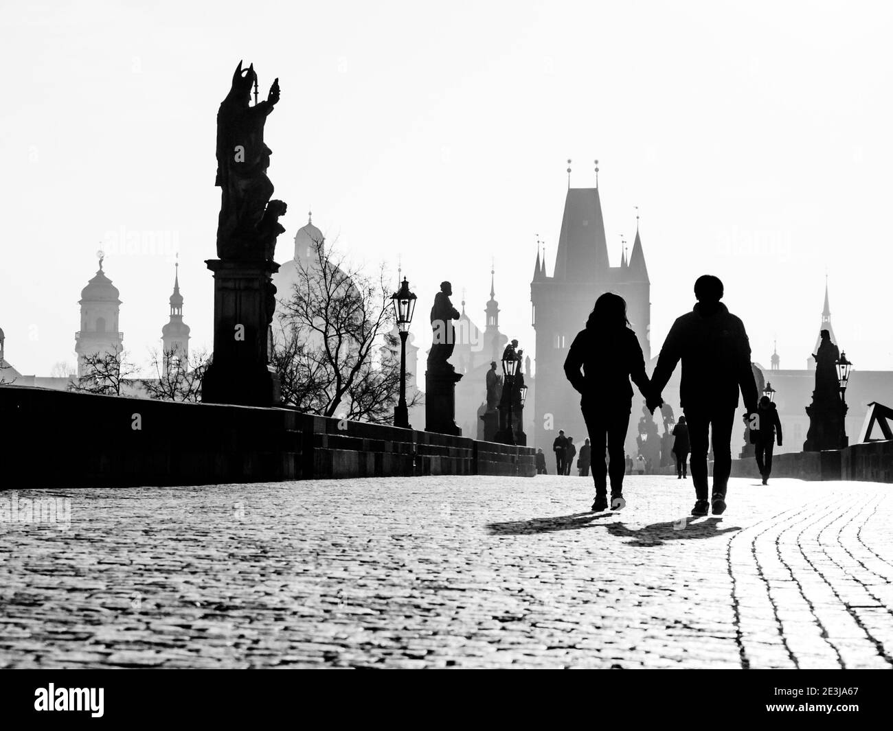 Mattina nebbia sul Ponte Carlo, Praga, Repubblica Ceca. Alba con sagome di persone a piedi, statue e torri della Città Vecchia. Viaggio romantico destionation. Immagine in bianco e nero. Foto Stock