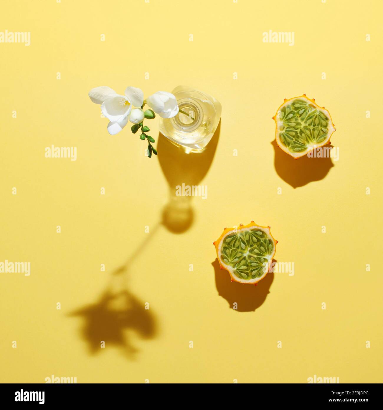 Scena creativa con frutta tropicale Kawani e fiore bianco su sfondo giallo. Concetto minimo. Foto Stock