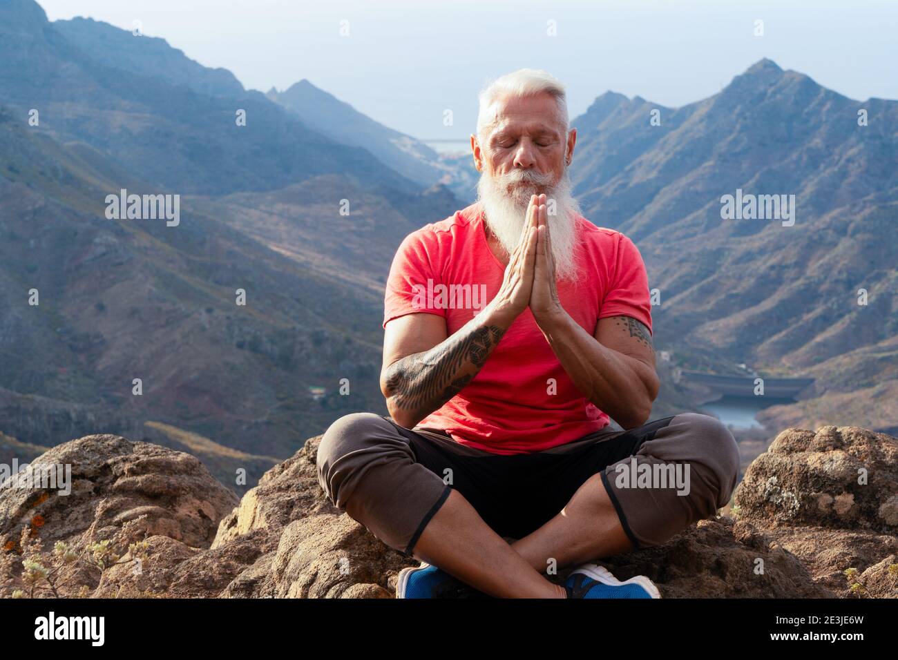 Uomo anziano saluto tramonto Foto Stock