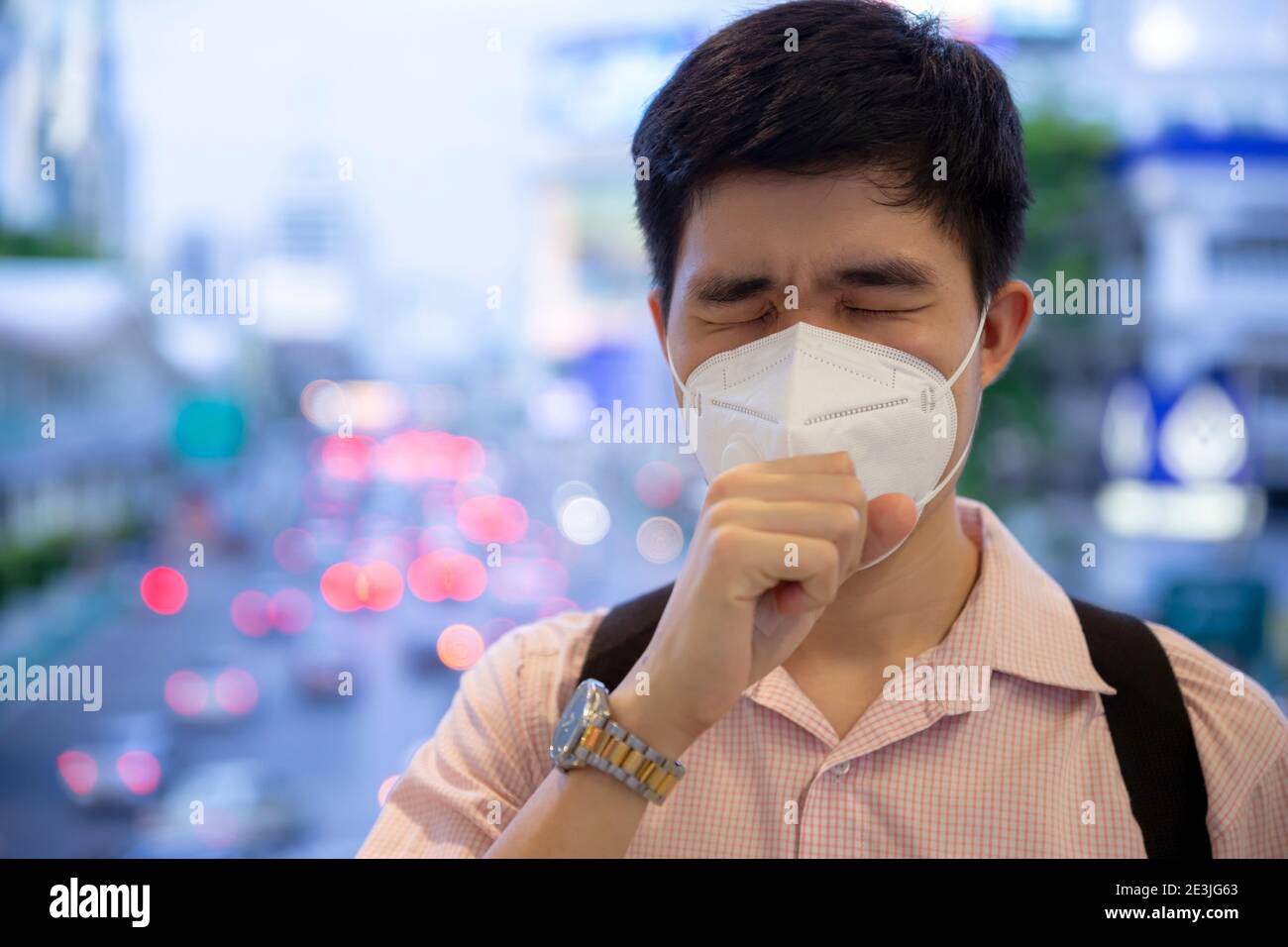 Un uomo che indossa la maschera della bocca contro l'inquinamento da smog d'aria con PM 2.5 nella città di Bangkok, Tailandia. Foto Stock