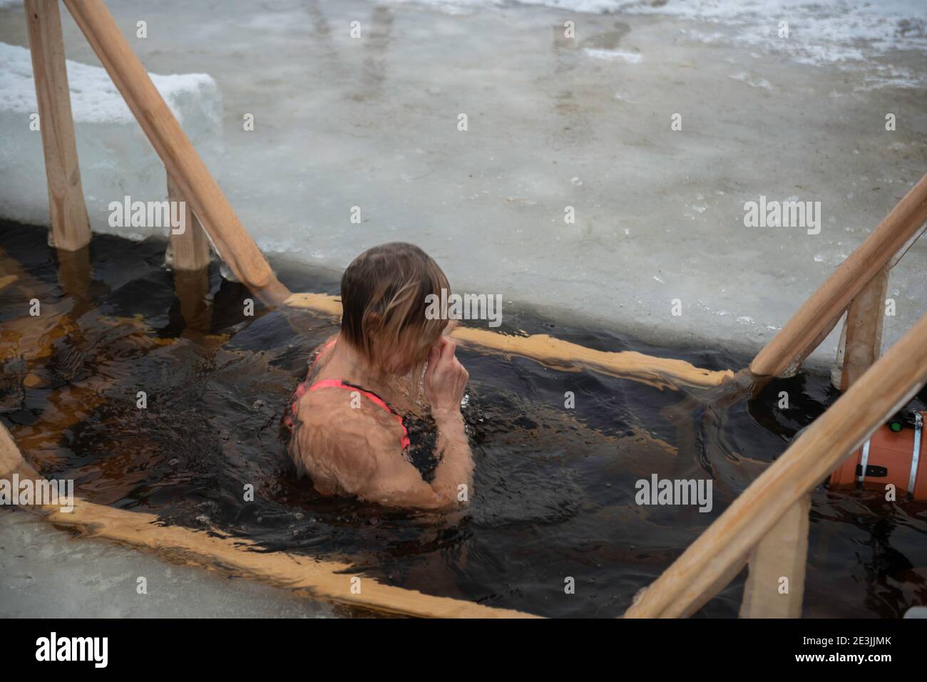Donna bagna in acqua fredda di ghiaccio-buco giorno di Epifania nel fiume  Neva, San Pietroburgo. Tradizionale nuoto ghiaccio nella chiesa ortodossa  Santa Epifania. S Foto stock - Alamy