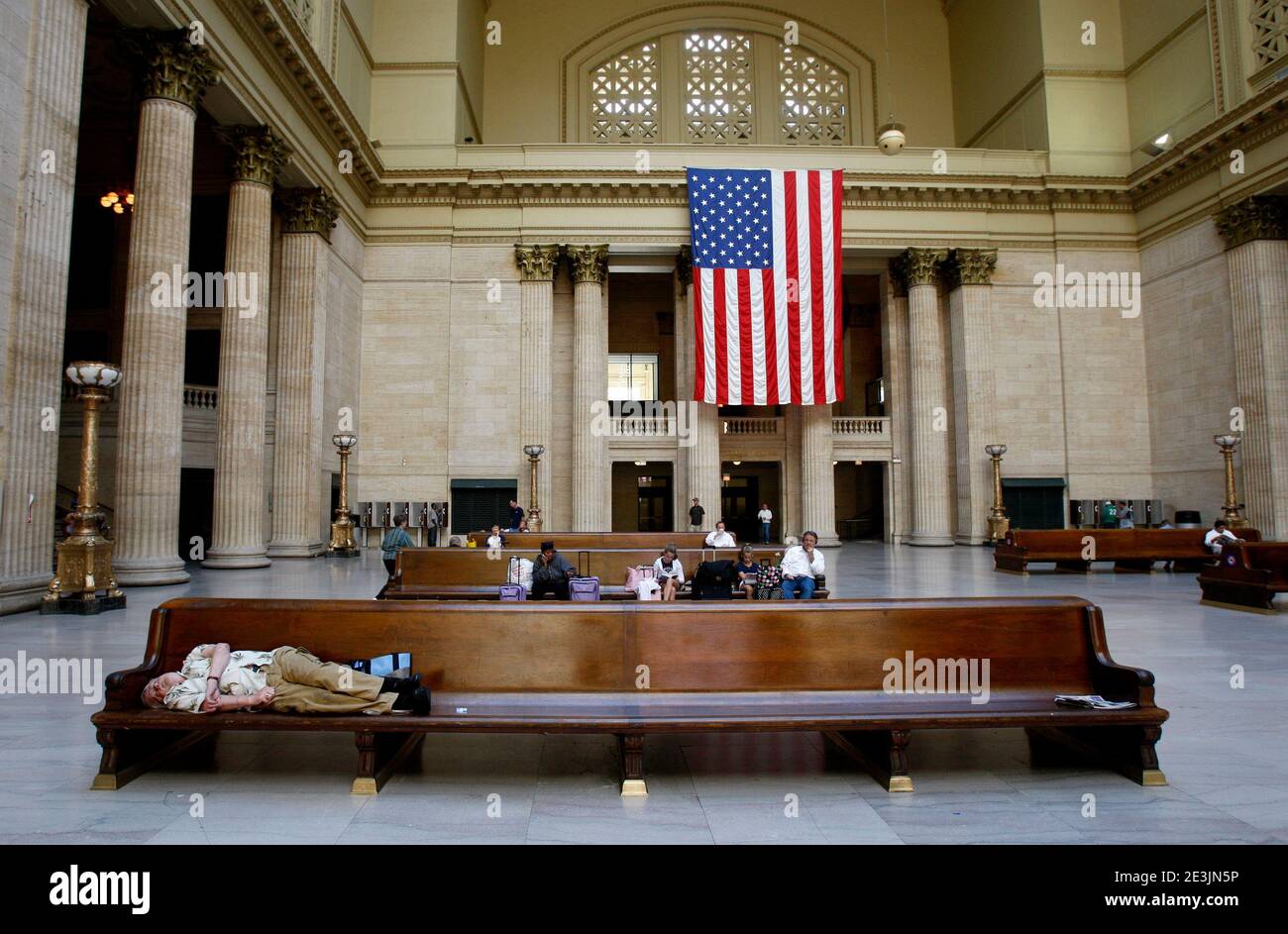 CHICAGO, USA- 3 OTTOBRE 2007: Sala d'attesa alla stazione ferroviaria di Chicago Union. Il viaggiatore stanco dormiva su una panchina prima del viaggio. Bandiera americana sullo sfondo. Foto Gippe Gustafsson Foto Stock