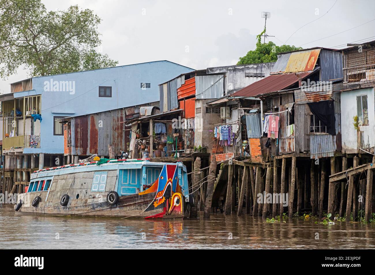 Case in palafitte e tradizionale barca di legno vietnamita nel delta del Mekong vicino a Can Tho, Vietnam Foto Stock