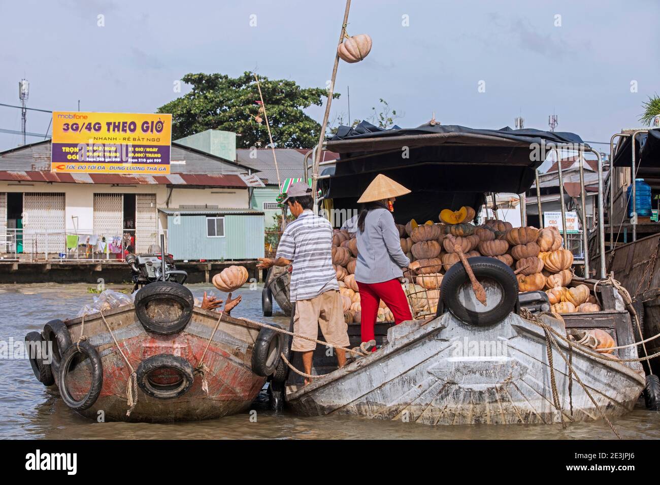 I contadini vietnamiti che vendono zucche di tradizionale barca di legno al mercato galleggiante della città Can Tho nel Delta del Mekong, Vietnam Foto Stock