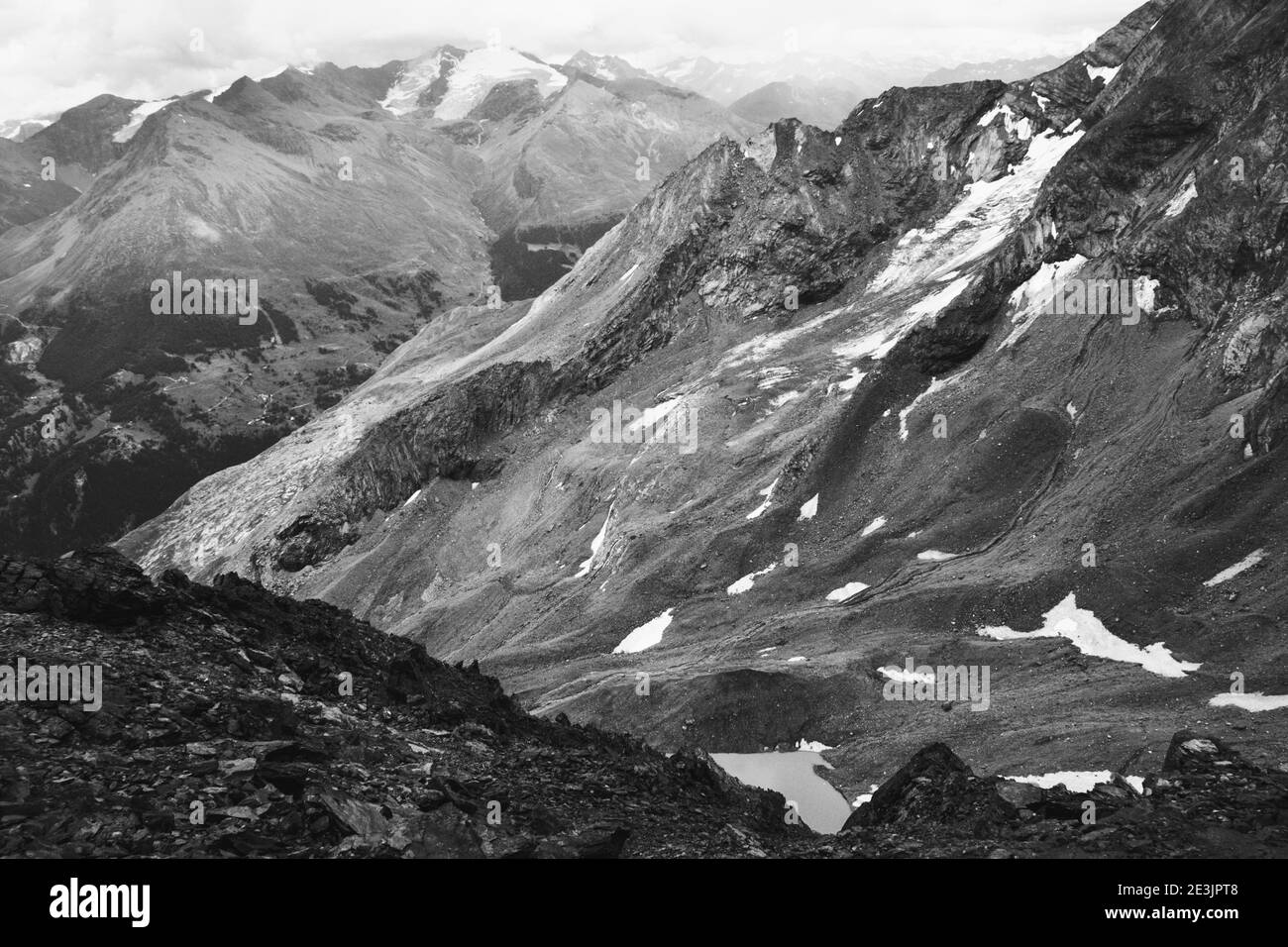 Maestoso paesaggio montano con lago e ghiacciai dalla stazione sciistica Les Arcs 2000 nel massiccio delle Red Peaks in estate. Savoia, Francia. Foto in bianco e nero Foto Stock