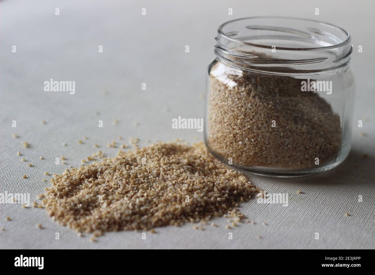 Grano rotto o grano spaccato o couscous è fatto da macinazione grani di grano grezzo interi grossolanamente utilizzati per rendere sano porridge Foto Stock