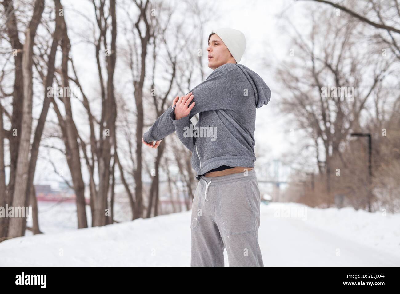 Giovane uomo in pantaloni da jogging che lavora fuori lungo acqua, Montreal, Quebec, Canada Foto Stock