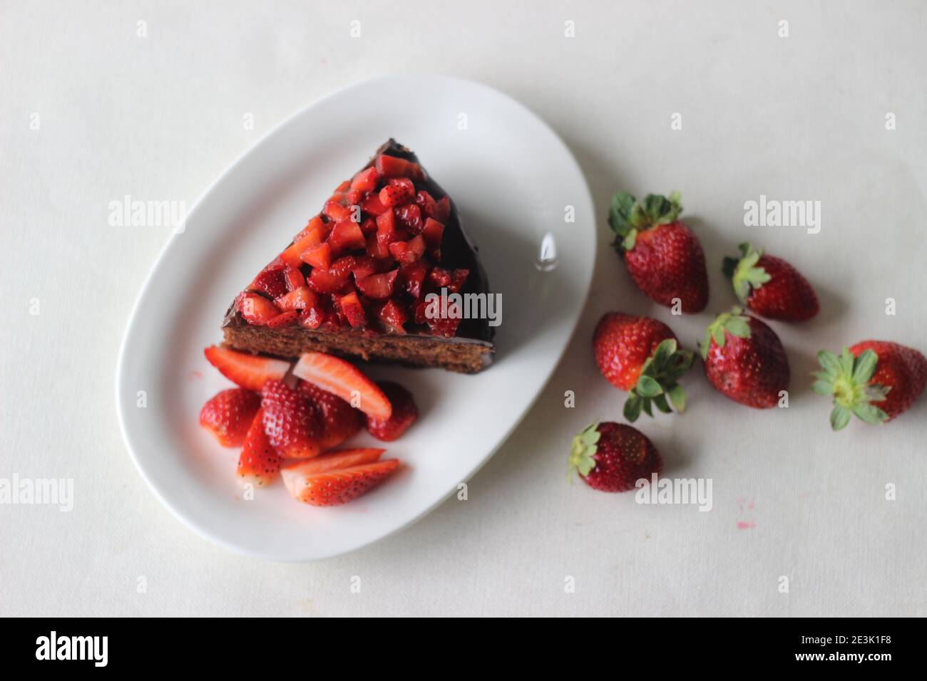 Fetta di torta al cioccolato con ganache al cioccolato e condita con fresco Fragole per un giorno di valentine e festa di Natale Foto Stock