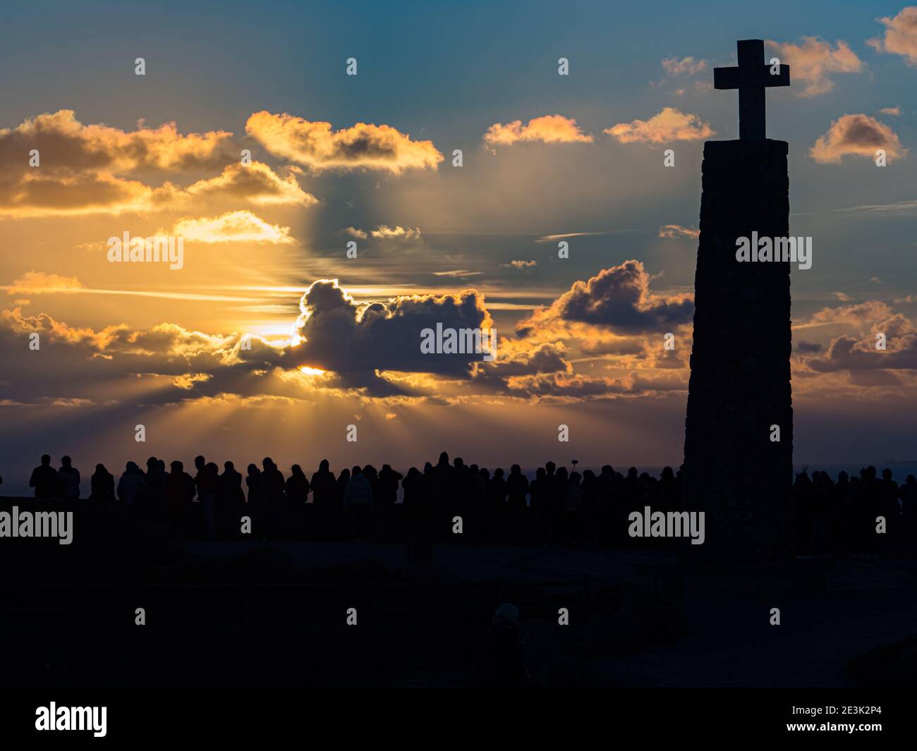 Sagome di persone e una grande croce sullo sfondo di un favoloso tramonto alla fine dell'Europa, Cabo da Roca, Portogallo Foto Stock