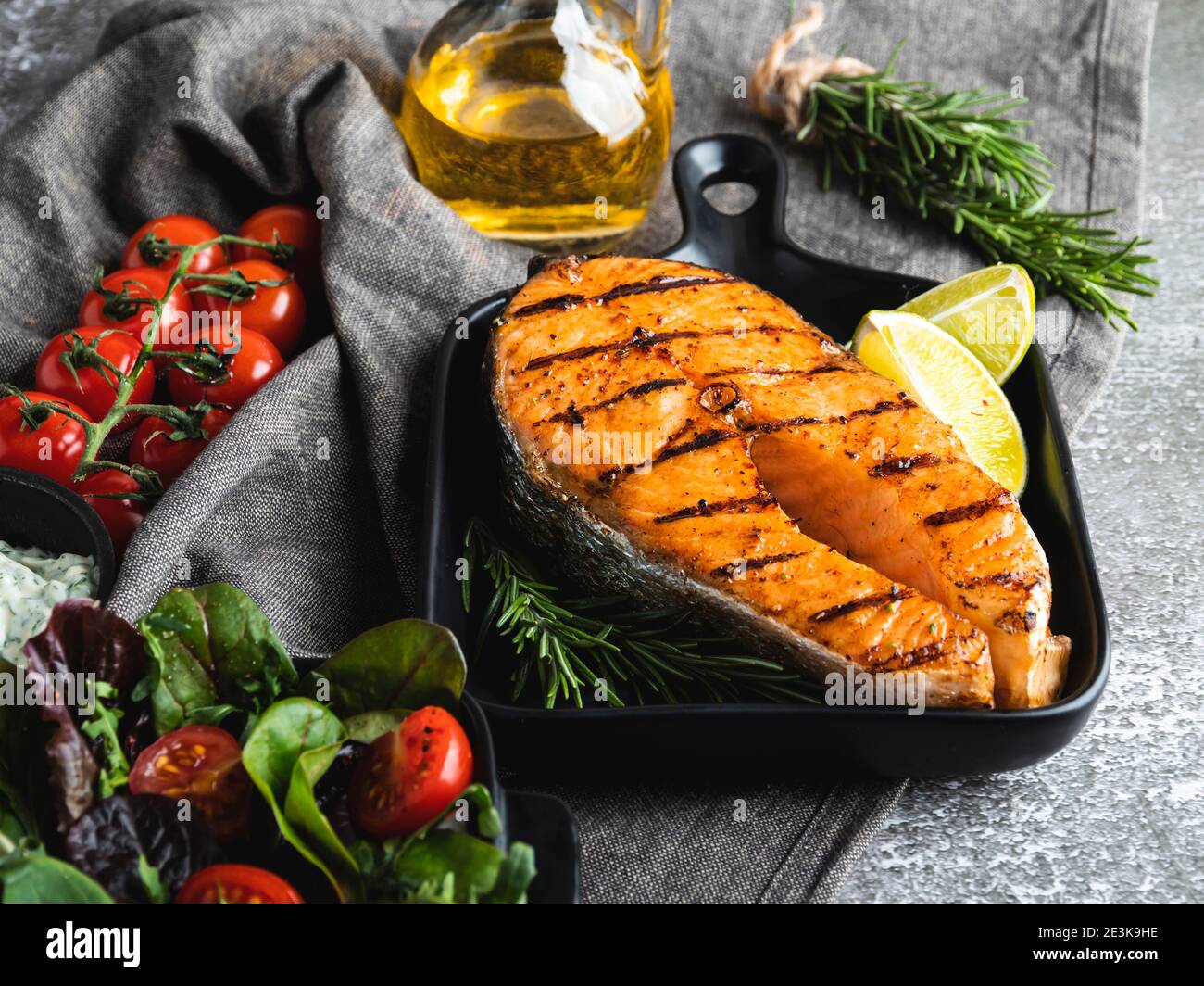 bistecca di salmone di pesce alla griglia, trote in padella alla griglia, spezie, rosmarino, pomodoro Foto Stock