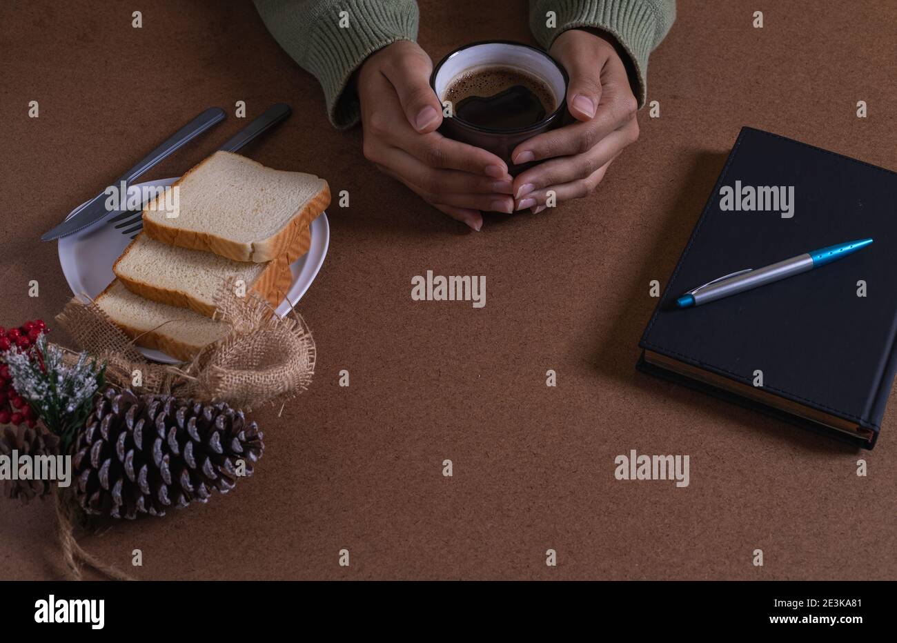 bere il caffè con il pane, creando nuove idee alla mia scrivania Foto Stock