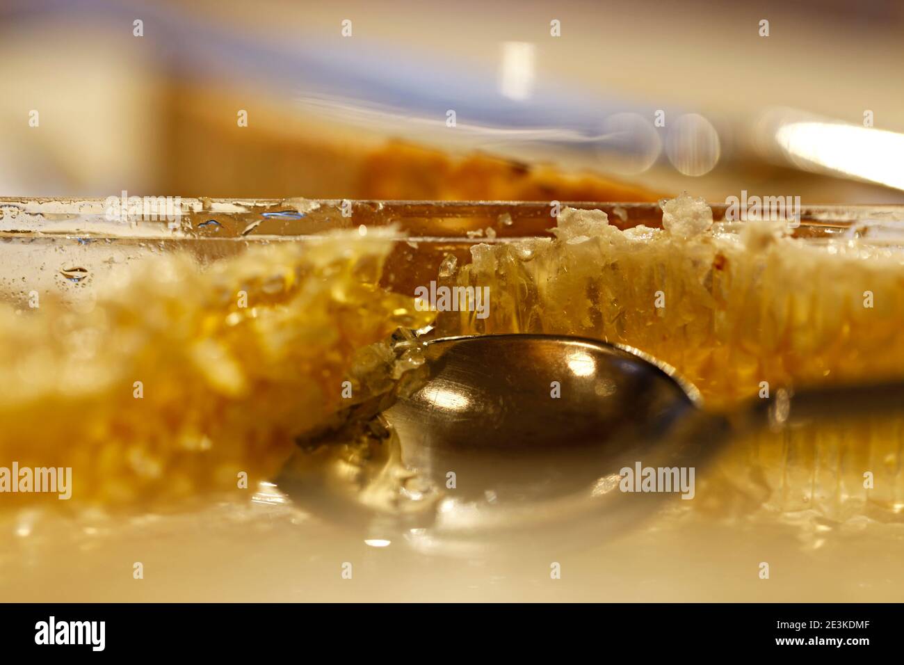 Primo piano del cucchiaio in nido d'ape, tagliare miele a pettine. Un cucchiaio di miele. Foto Stock